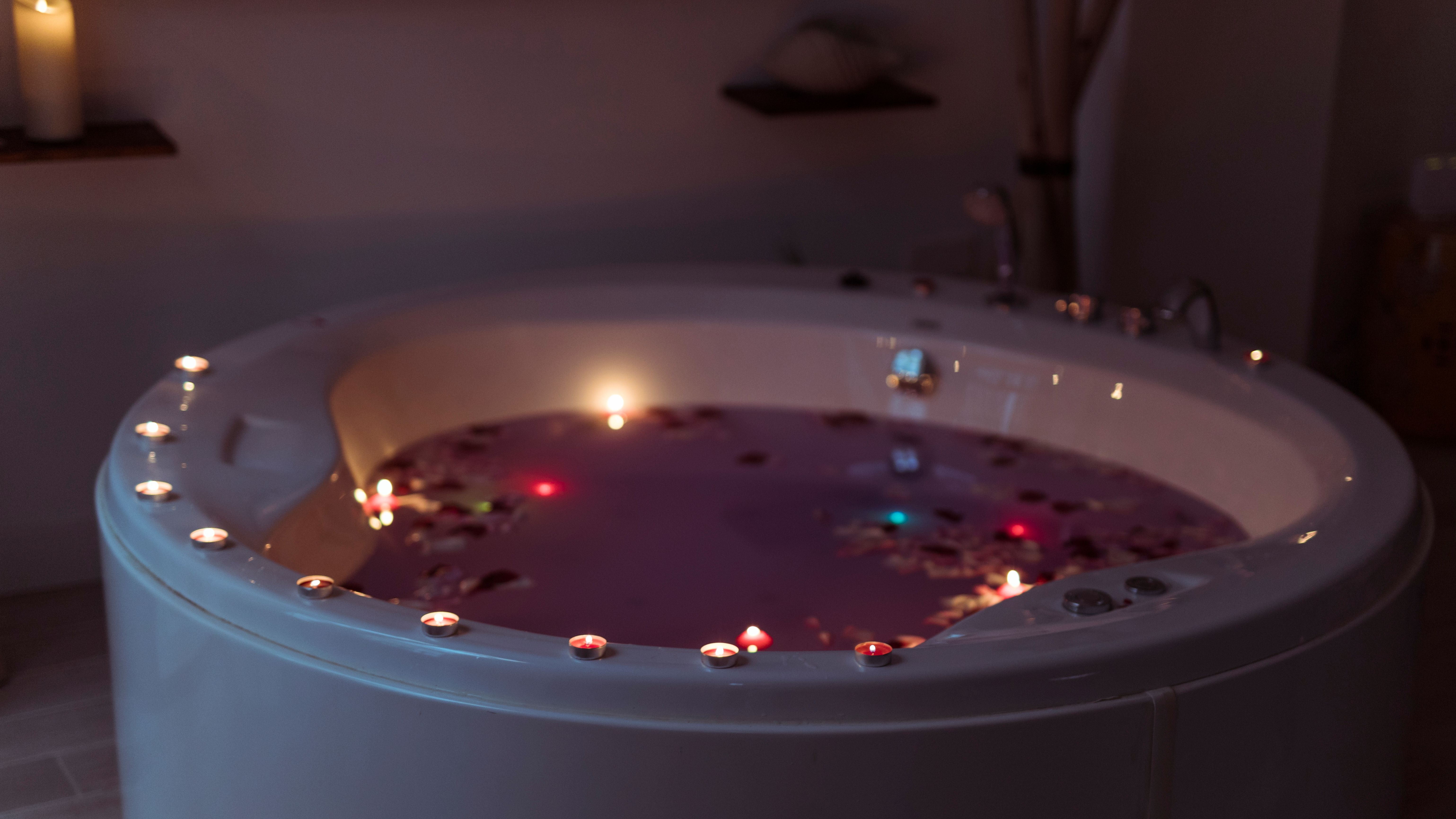 flower-petals-spa-tub-with-violet-water-burning-candles-edges.jpg